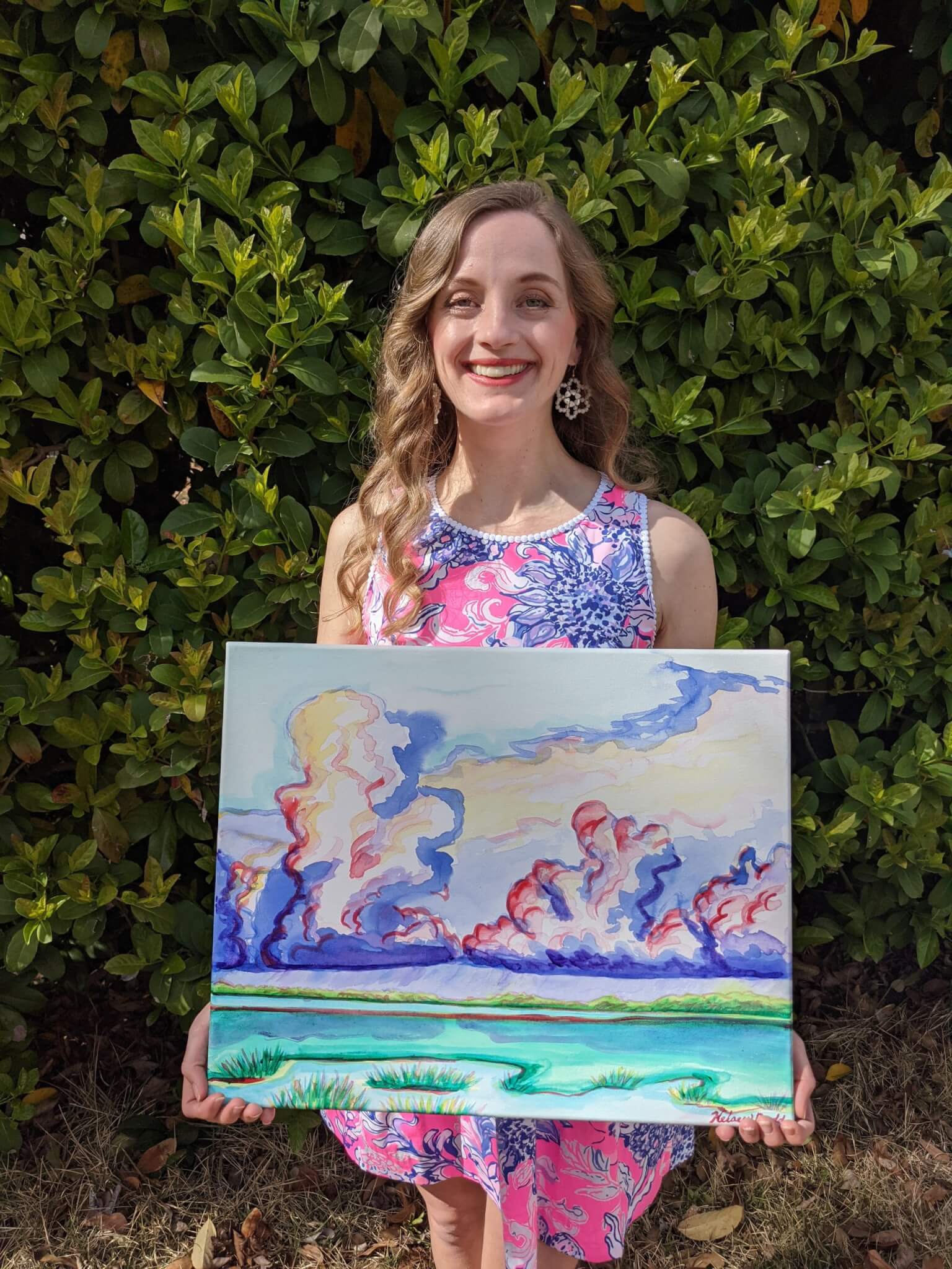 Kelsey Budd holding one of her paintings